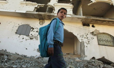 A Palestinian boy walks past a house in Beit Lahiya damaged during Israel's three-week offensive. Photograph: Suhaib Salem/Reuters